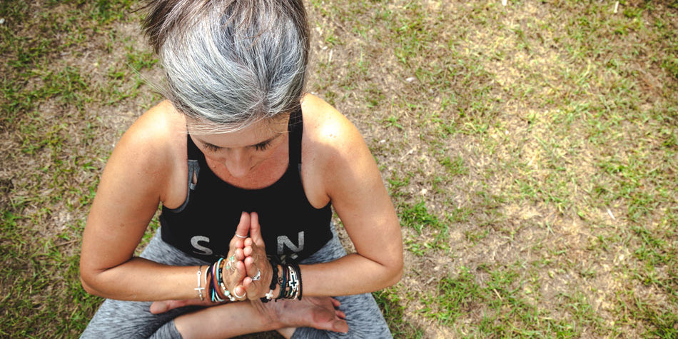 A middle-aged woman meditating in a park